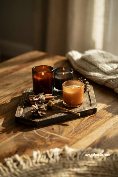 Cozy fall candle vignette with amber glass jars on a wooden coffee table tray