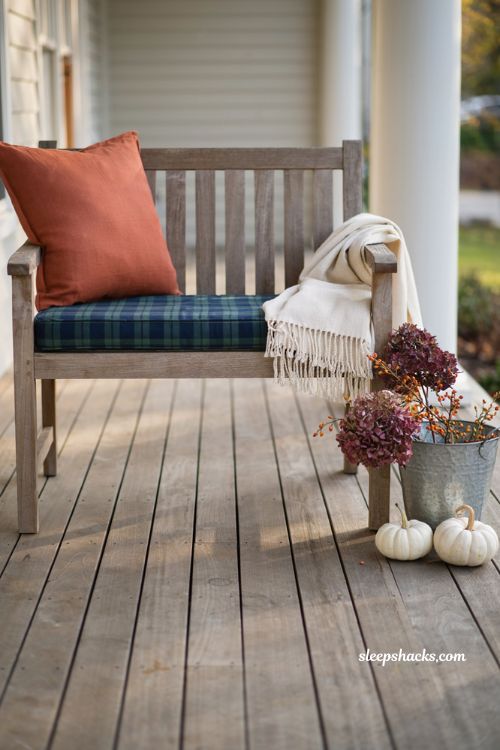Cozy fall porch decor with plaid cushions throw blanket and rustic bucket styling