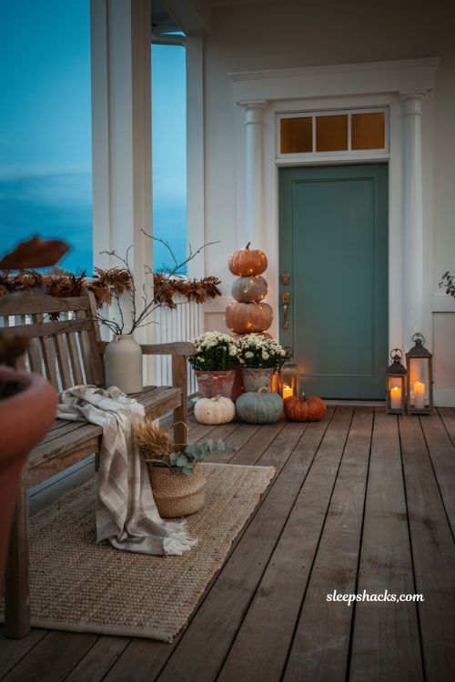 Cozy fall porch with a glowing lighted pumpkin topiary by the front door