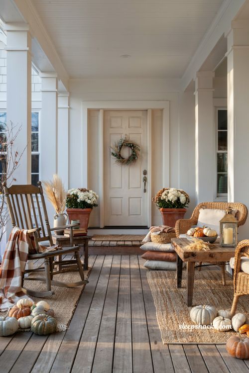 Cozy fall porch with multiple seating areas for warm and inviting autumn gatherings