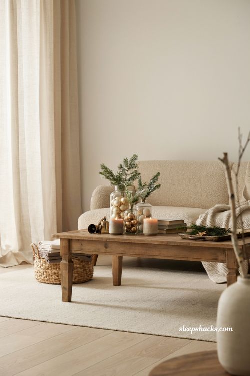 Cozy neutral christmas coffee table with apothecary jars filled with cream and gold ornaments