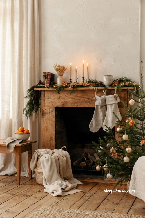 Cozy neutral christmas mantel decor with dried orange slices greenery and warm candlelight