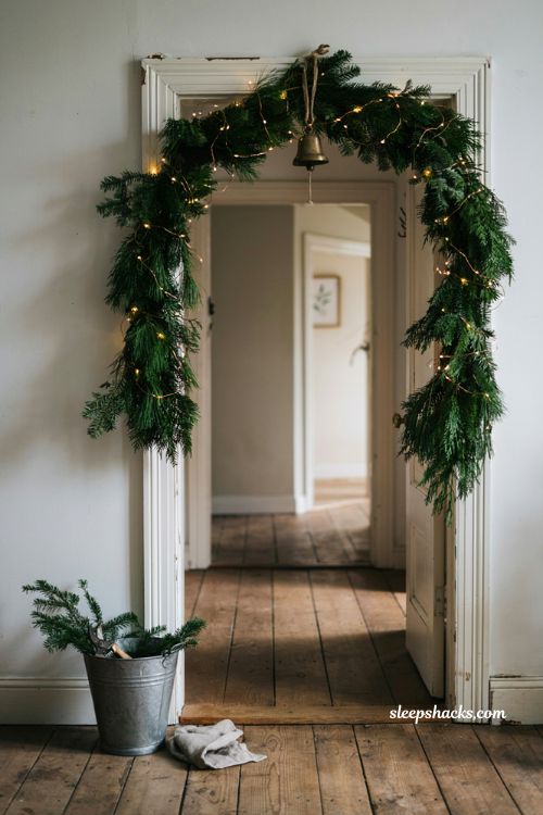 Diy fresh evergreen garland Christmas doorway decor ideas with fairy lights and twine