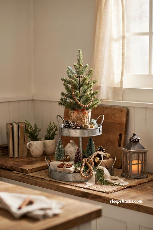 Dollar tree mini christmas tree ideas with a tiered tray display for a cozy farmhouse kitchen