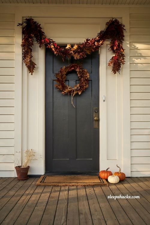 Draped autumn leaf garland over front door with matching fall wreath for porch decor