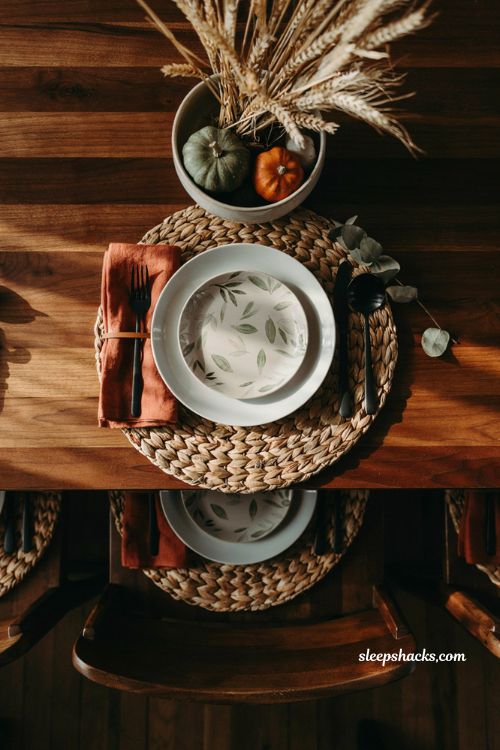 Fall dining table place setting with woven placemats and rust linen napkins