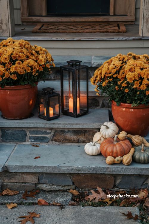 Cozy fall front steps decor with pumpkins and lanterns with a warm amber glow