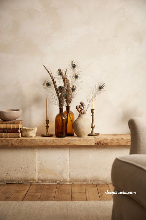 Fall home decor ideas with feathers in amber glass vases for elegant autumn styling