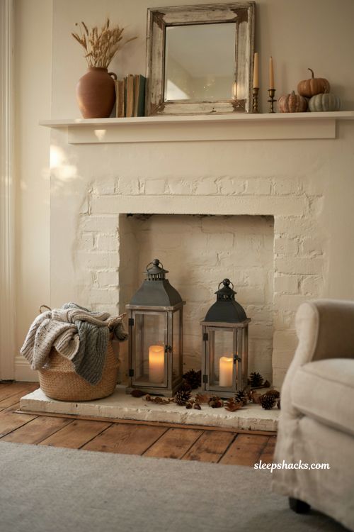Fall mantle decor with black lanterns on a cozy farmhouse fireplace hearth for elegant autumn contrast
