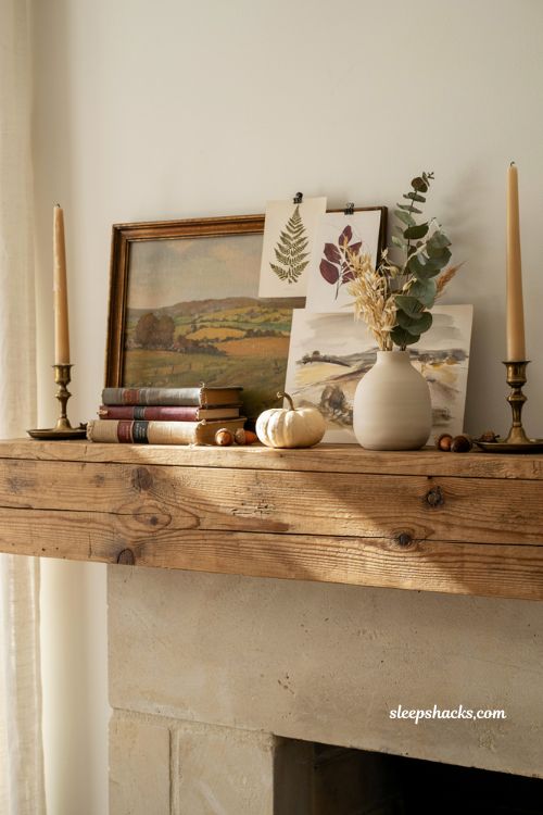 Fall mantle decor with layered framed artwork and cozy farmhouse fireplace styling