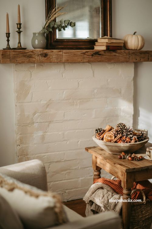 Fall mantle decor with pinecone and potpourri bowl beside a cozy farmhouse fireplace