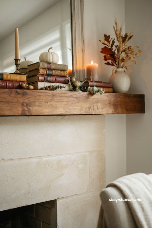 Fall mantle decor with stacked vintage books and cozy farmhouse fireplace styling