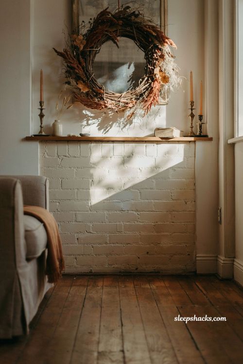 Fall mantle decor with statement grapevine wreath above a cozy farmhouse fireplace