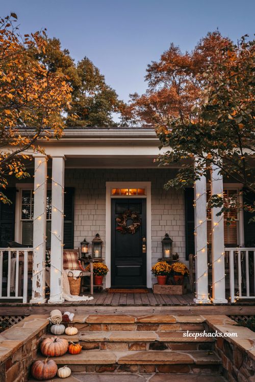 Fall outdoor decor ideas with warm string lights on a cozy autumn porch