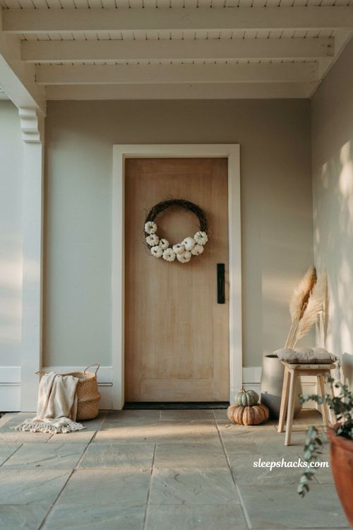 Fall patio decor with a minimalist white pumpkin wreath on the door