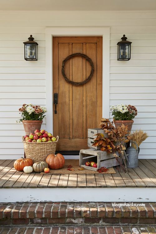 Fall porch decorating ideas with woven basket of apples pumpkins and autumn mums