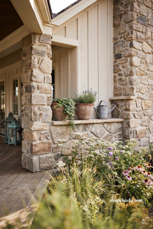 Farmhouse exterior ideas featuring a traditional fieldstone foundation wrap and coordinating stone porch columns for a timeless rooted look