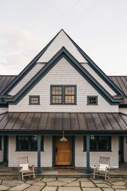 Farmhouse exterior ideas with a steep central gable roof and dark charcoal trim for classic architectural contrast