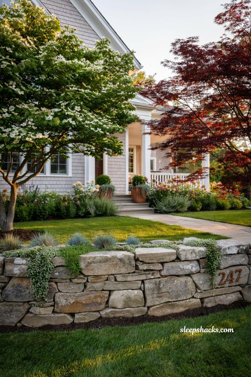 Front lawn landscaping ideas with stone retaining wall and cascading planting pockets