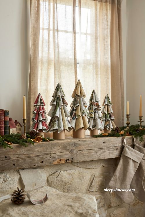 Handmade junk mail christmas trees on a rustic mantel with recycled holiday decor