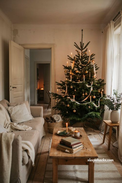 Cozy neutral christmas living room decor with clip on candle lit tree and warm european holiday charm