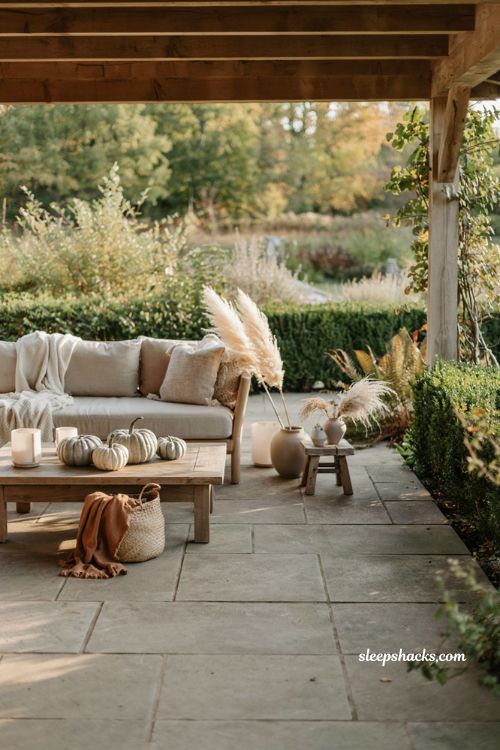 Neutral fall patio decor with white pumpkins and cozy natural textures