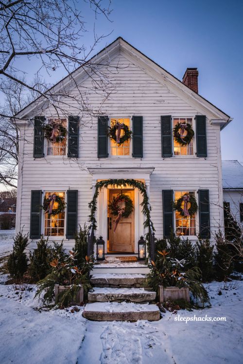 Outdoor christmas house with wreaths on every window and classic farmhouse holiday decor