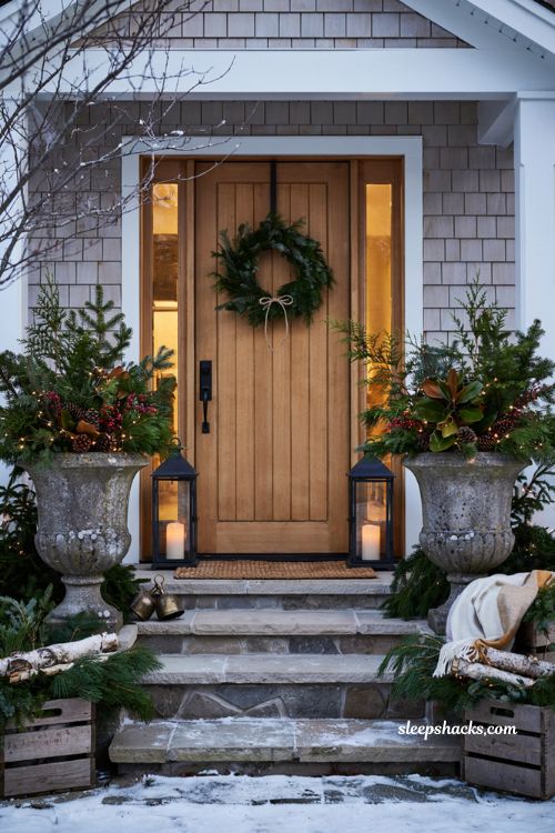 Outdoor christmas urns with cordless lit greenery pinecones and cozy front porch decor