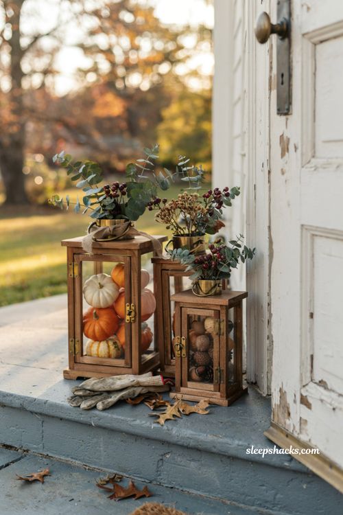 Rustic outdoor fall decor ideas with clustered wood lanterns filled with pumpkins seed pods and berries on porch steps