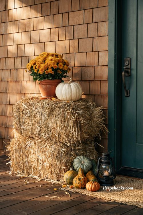 Rustic outdoor fall porch decor ideas using stacked hay bales with pumpkins and mums