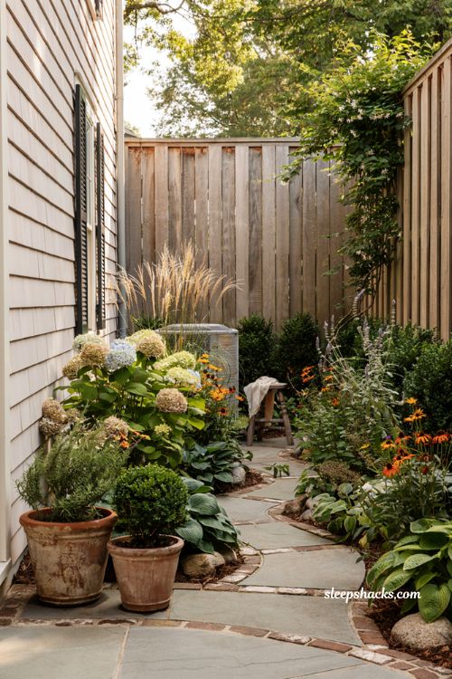 Side yard landscaping ideas with hidden ac unit and layered cottage garden plants