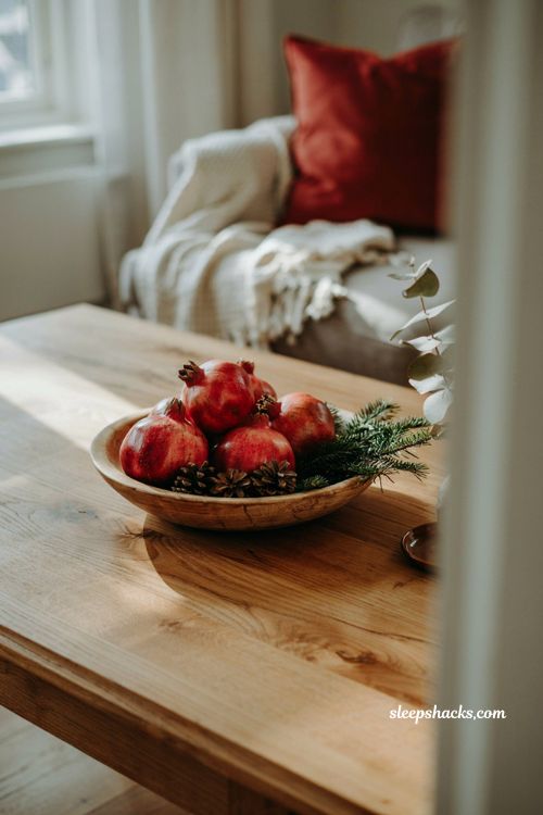 Simple christmas coffee table centerpiece idea with fresh pomegranates in a wooden bowl