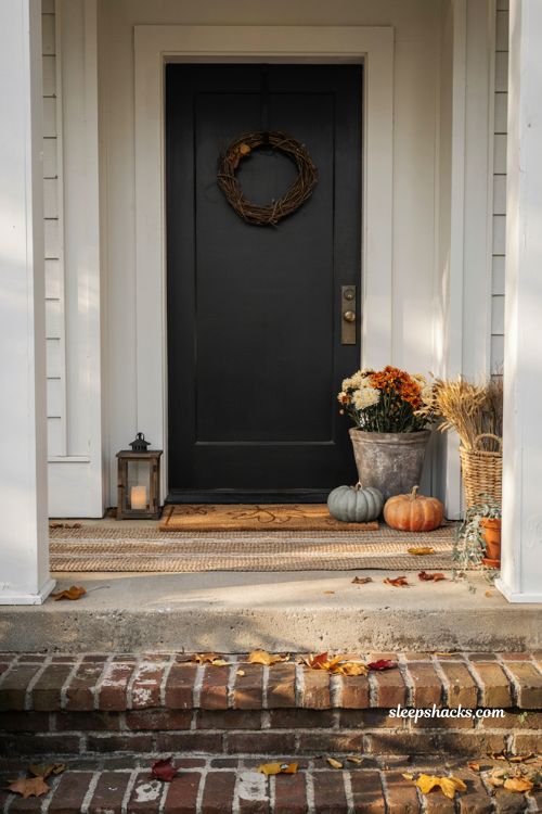 Simple fall porch decorating ideas with layered outdoor rug under doormat and cosy farmhouse autumn entry