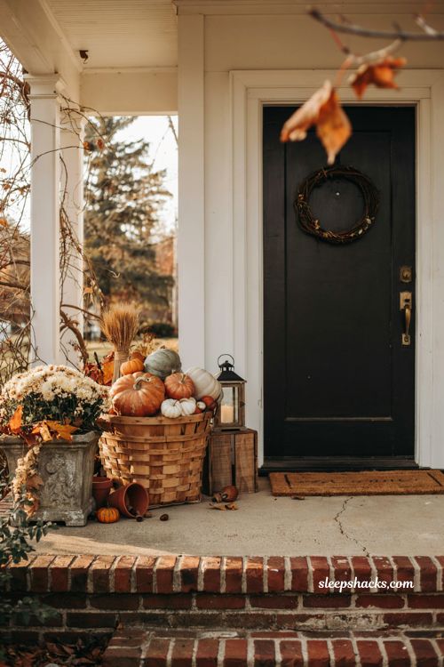 Simple fall porch decorating ideas with vintage bushel basket pumpkins and cosy farmhouse autumn entry