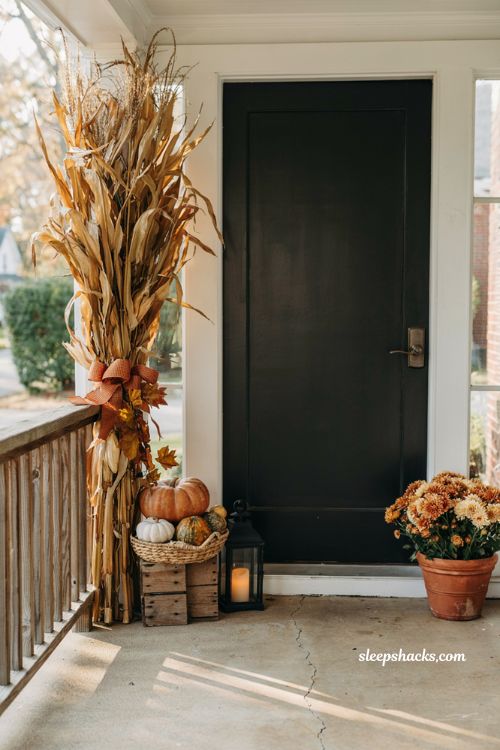 Small front porch fall decor ideas with bundled corn stalks pumpkins and cosy farmhouse autumn entry