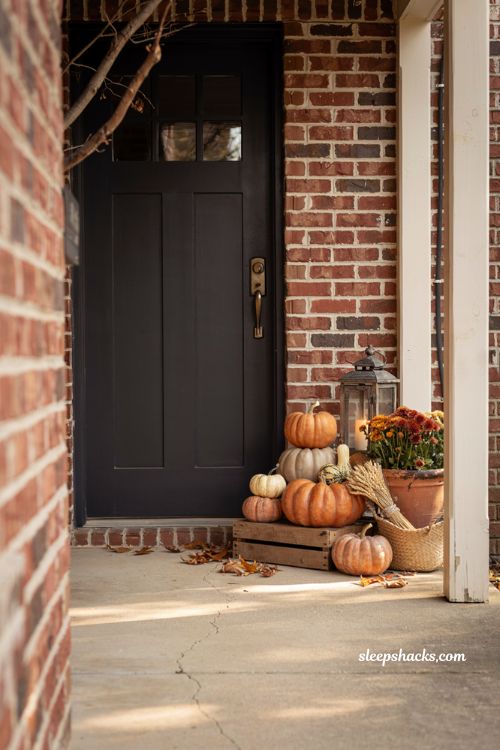 Small front porch fall decor ideas with terracotta pumpkins and cosy farmhouse autumn entry