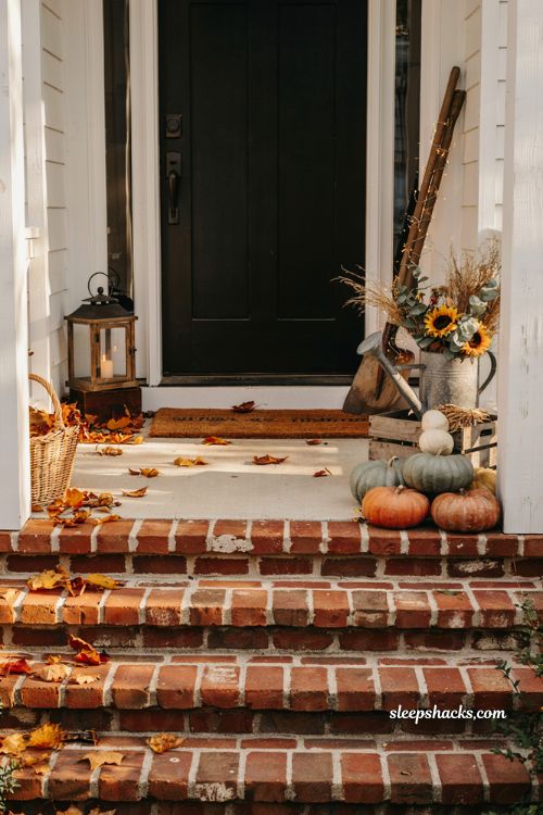 Small front porch fall decor ideas with vintage garden tools galvanized watering can and cosy farmhouse autumn styling