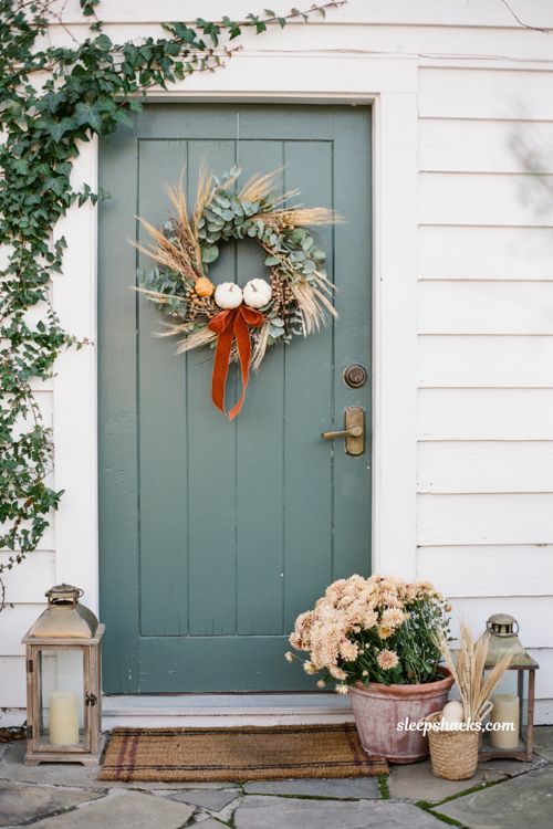 Statement fall wreath on green front door with velvet ribbon and autumn porch decor