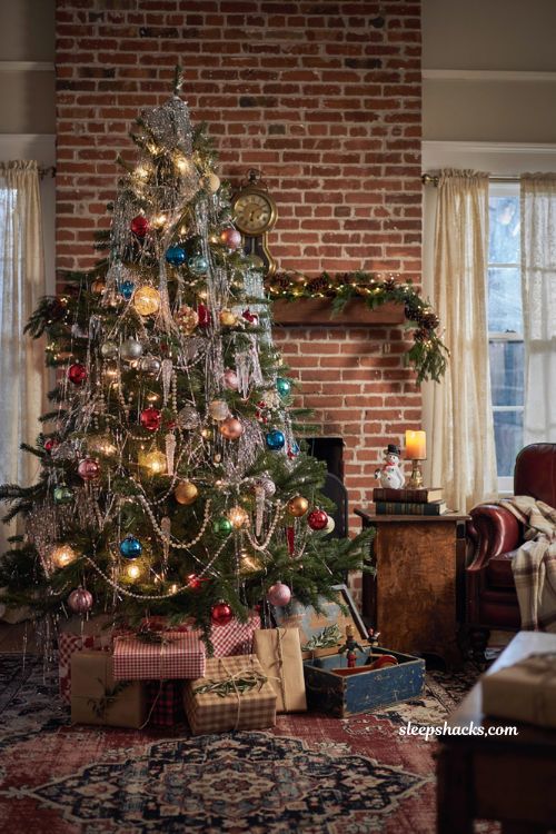 Themed christmas tree ideas with dazzling silver tinsel and vintage colorful ornaments in a retro living room