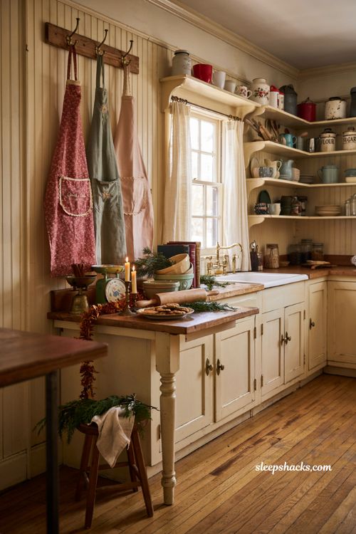 Vintage christmas decor diy with vintage aprons displayed on a farmhouse kitchen peg rail