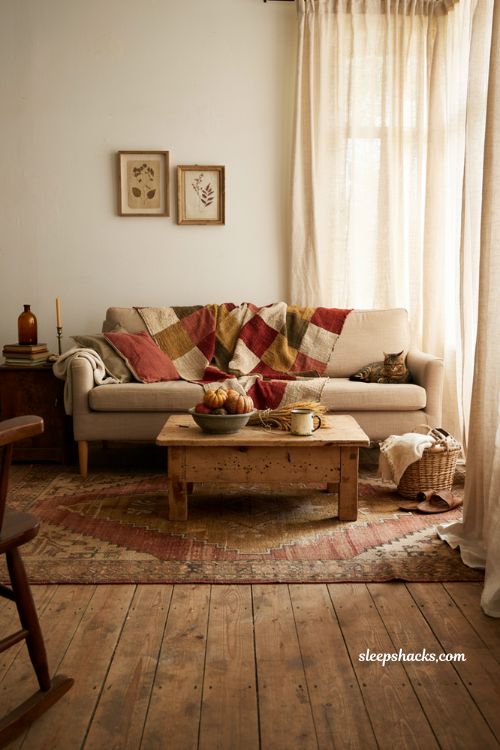 Vintage fall decor ideas with a hand stitched quilt draped over a cozy farmhouse sofa