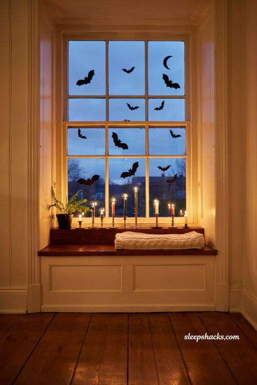 black bat silhouette window clings glowing with warm indoor light for halloween