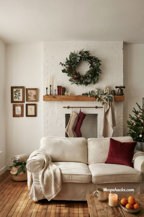 cozy christmas wall decor ideas for a warm living room with greenery and vintage details