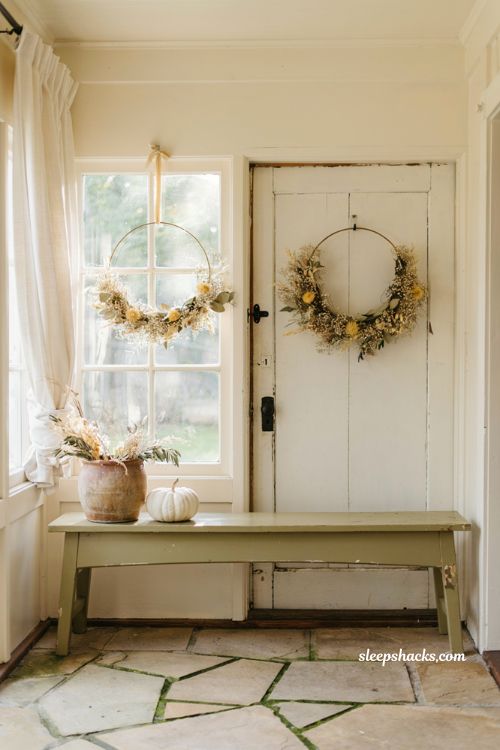 delicate dried floral hoop wreath hanging on an entryway porch window