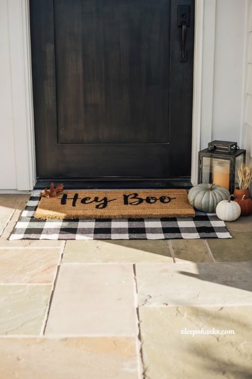 layered halloween doormat with pumpkins on a cozy fall front porch