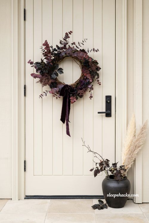 moody and dramatic dark burgundy and plum asymmetrical fall wreath for a statement front door