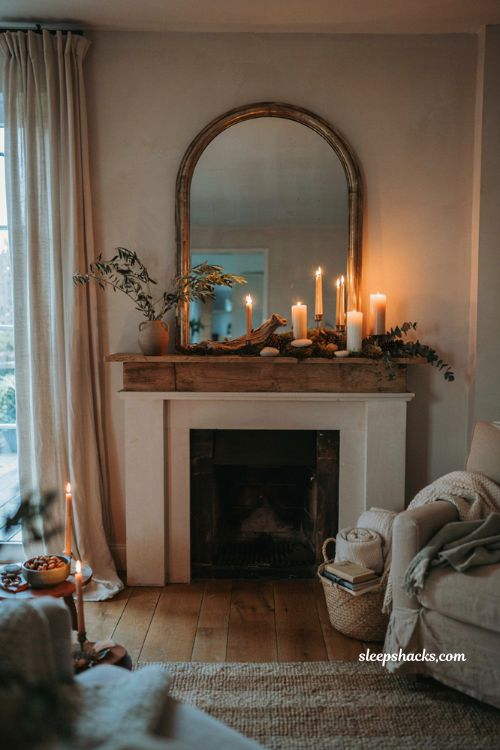 Asymmetrical fall mantel with pillar candles moss and cozy autumn decor