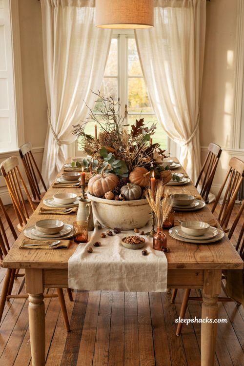 Autumn centerpiece ideas with dough bowl pumpkins branches and cozy dining table