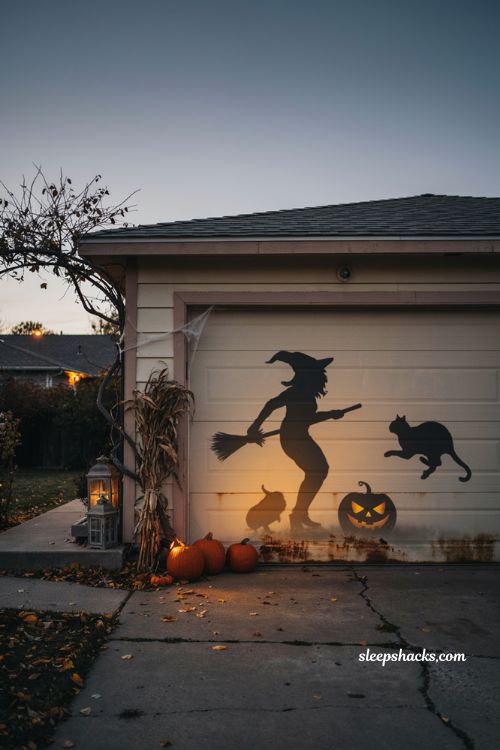 Backlit Halloween exterior decorations with witch cat and jack o lantern silhouettes 