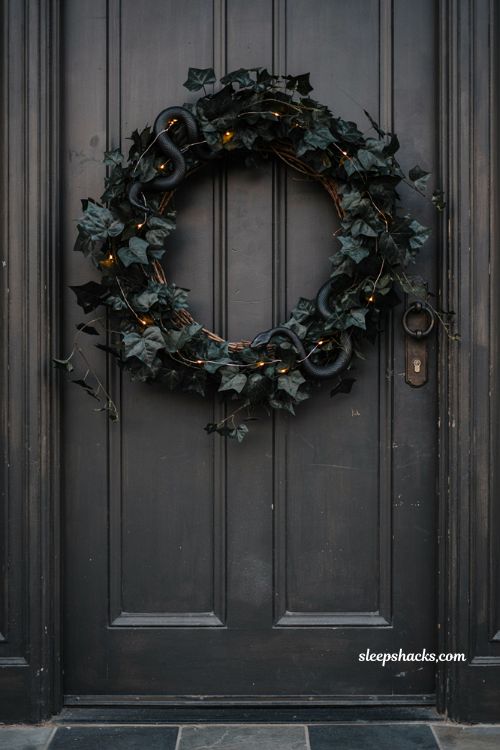 Black ivy and snake wreath with gothic Halloween grapevine decor and orange fairy lights 